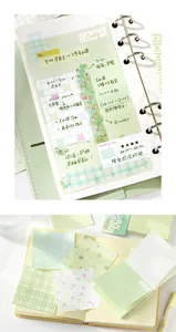 Detailed view of a fresh green sticky note memo pad set with grid and clover patterns in a notebook