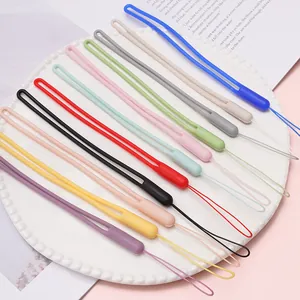 Dettaglio ravvicinato di cinturini per telefono in silicone colorati su piatto bianco.