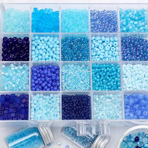 Close-up of assorted blue glass seed beads organized in a clear compartment box