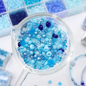 Close-up macro view of mixed blue glass beads in a glass scoop for DIY jewelry making