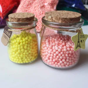 Decorative colorful foam balls in glass jars for DIY crafts and gift box stuffing