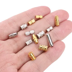 Detailed view of gold and silver metal screw clasps for DIY jewelry making in hand