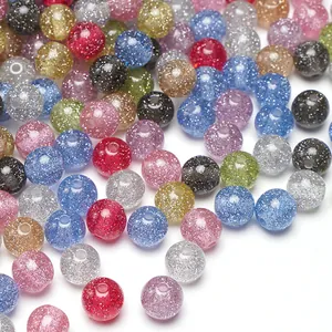 Makro-Detail von bunten Harzperlen mit glitzerndem Silberstaub für DIY-Schmuckherstellung