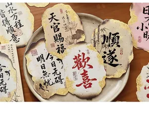 Close-up of vintage Chinese calligraphy postcards with burnt gold foil edges and floral art
