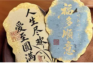 Detail of vintage Chinese postcards with gold foil edges and inspirational calligraphy.