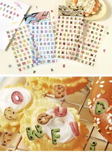 Nahaufnahme von realistischen Alphabet-Keks-Aufklebern auf köstlichen Desserts