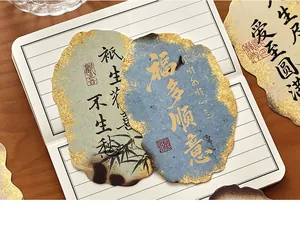 Macro view of vintage ancient style postcards with gold leaf edges and calligraphy.