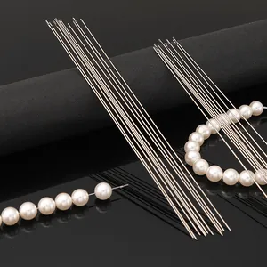 Close-up of stainless steel side-opening beading needles with white craft pearls