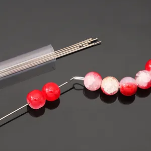 Detailed view of stainless steel beading needles threading red beads for DIY jewelry