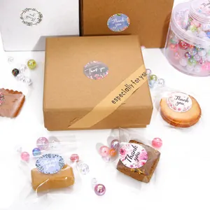 Round floral Thank You stickers on kraft boxes and bags for elegant gift packaging.