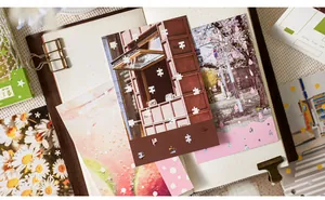 Detalle de postales de paisajes estéticos colocadas en un cuaderno vintage