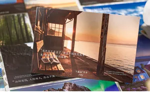 Primer plano de postales de paisajes con citas inspiradoras bajo la luz del atardecer.