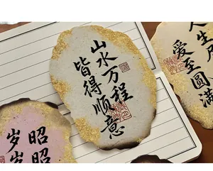 Detail view of ancient style postcards with Chinese calligraphy and gold leaf edges.