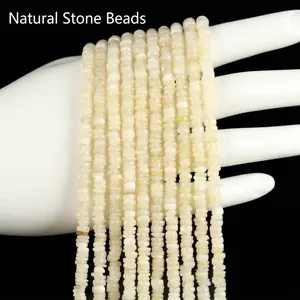 Macro view of 3mm natural white shell disc beads held in hand for jewelry making