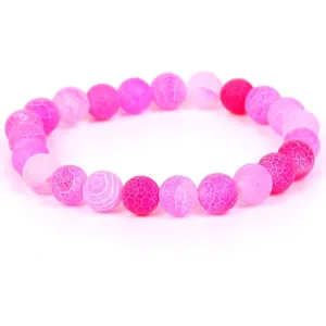 Close-up detail of pink weathered stone beads showing natural cracked texture on a bracelet