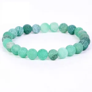 Detailed view of green weathered stone beads bracelet with unique crackle texture