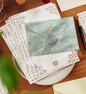 Detail eines Vintage-Briefpapier-Sets mit goldgeprägtem Briefbogen und Umschlag.