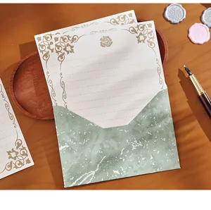 Detailansicht eines Vintage-Briefpapier-Sets mit geprägtem Papier und grünem Umschlag