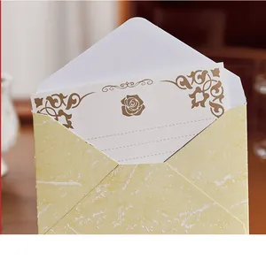Nahaufnahme eines vintage geprägten Goldfolien-Umschlags und Briefpapier-Sets mit Rose