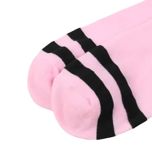 Close-up detail of pink knee-high socks with two black stripes for costume parties