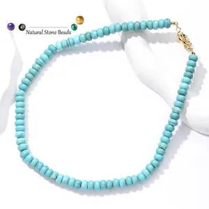 Detailopname van een turkooizen kralenketting met een goudkleurige veerringsluiting.