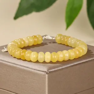 Close-up detail of yellow natural stone abacus beads and silver clasp on a jewelry box
