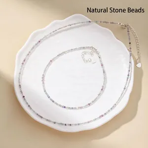 Detail view of faceted natural stone necklace and anklet set with silver heart charms.