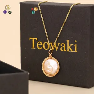 Detalle de collar de perla barroca redonda envuelta en alambre en caja de regalo negra
