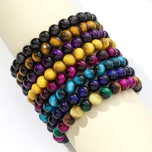 Close-up of colorful round glass tiger eye beads stacked on a display stand