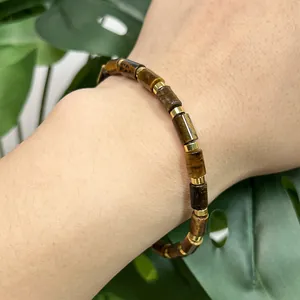 Detail view of natural yellow tiger eye cylinder beads bracelet with gold spacers