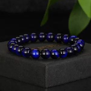 Detailed view of blue and black cat eye glass beaded bracelet on a black gift box