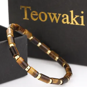 Close-up of a natural tiger eye cylindrical bead bracelet featuring gold-colored spacers