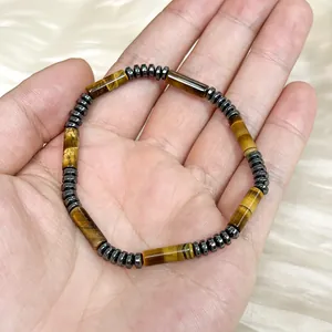 Detail shot of tiger eye cylinder bead bracelet with hematite spacers in hand