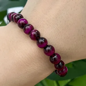 Detailed close-up of a purple cat eye glass bead bracelet worn on a person's wrist.