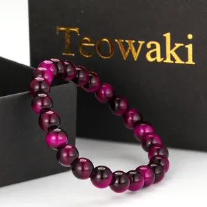 Close-up detail of a purple cat-eye beaded bracelet inside a stylish black gift box