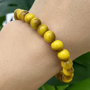 Detailed view of yellow cat eye glass beads bracelet with smooth polished finish