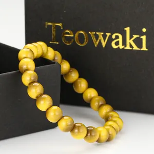 Macro view of yellow round glass beads bracelet with tiger eye effect and gift box