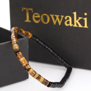 Detail view of natural tiger eye and black cylindrical bead bracelet in gift box
