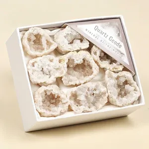 Gros plan de géodes de quartz blanc naturel dans une boîte cadeau avec étiquettes