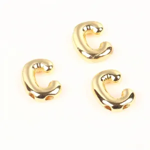 Detailed view of 20mm gold copper letter C beads with a shiny balloon-like texture.
