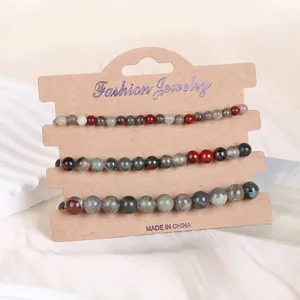 Detailansicht von 3er-Set Naturstein-Armbändern in Erdtönen auf Kraftkarton-Display
