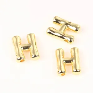 Detail view of 20mm gold copper H-letter beads with bamboo texture for DIY jewelry.