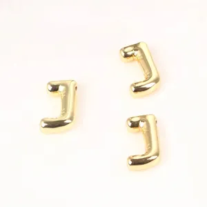 Detailed close-up view of three 20mm golden copper letter J beads for DIY jewelry