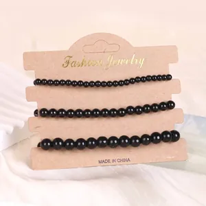 Handgefertigtes dreiteiliges Set aus schwarzen Achat-Perlenarmbändern auf Präsentationskarte
