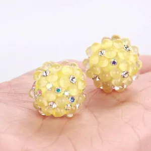 Close-up of yellow polymer clay bubble beads with sparkling rhinestone accents for DIY