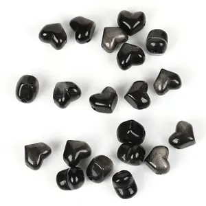 Close-up detail of 13mm heart-shaped natural black obsidian stone beads for DIY jewelry