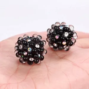 Close-up of black bubble beads with colorful rhinestones for DIY jewelry making.