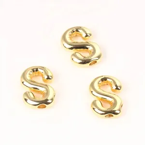 Detailed view of three 20mm shiny gold copper letter S beads for DIY jewelry making