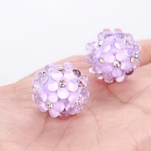 Close-up of purple bubble beads with rhinestones for DIY jewelry making.
