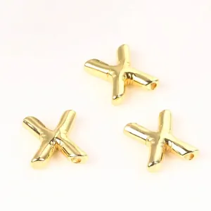 Close-up of golden balloon-style X letter copper beads for DIY jewelry